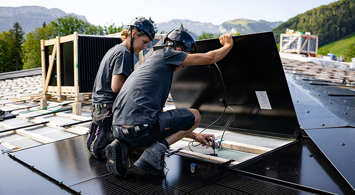 Zwei Solarinstallateure arbeitet auf Steildach und installierte eine Solaranlage Gebäudehülle Schweiz Zwei Solarinstallateure arbeitet auf Steildach und installierte eine Solaranlage Gebäudehülle Schweiz